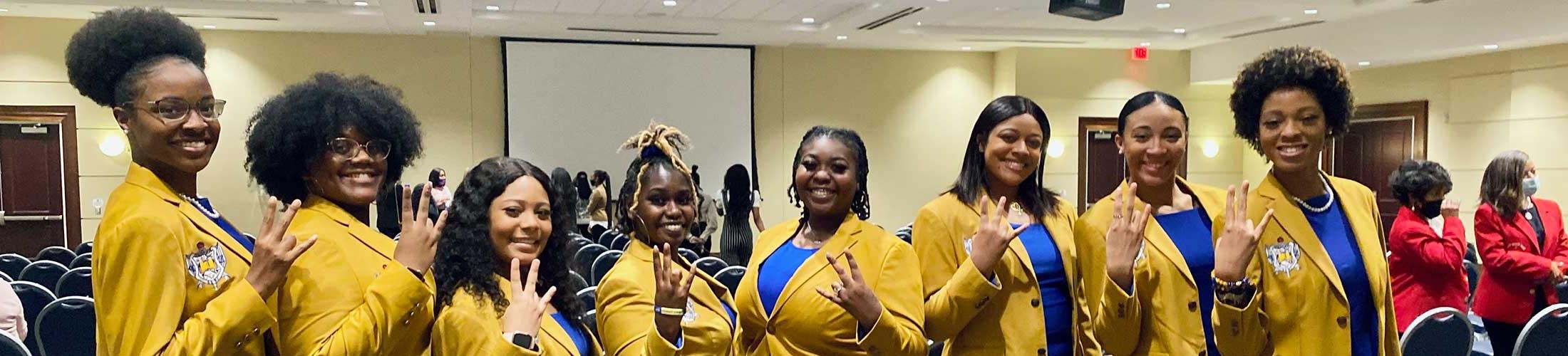 Sigma Gamma Rho members in yellow and blue.